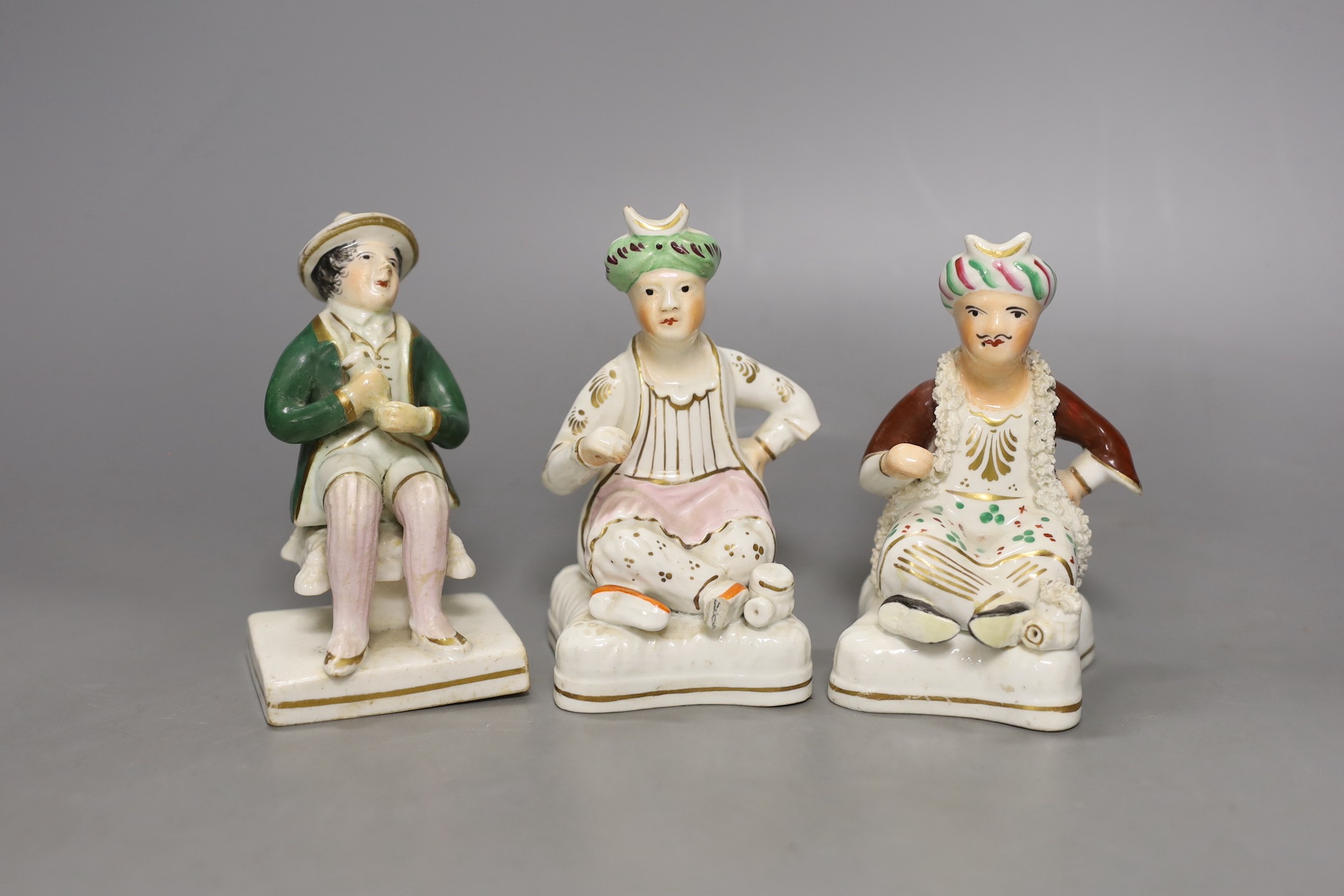 Two 19th-century Staffordshire porcellanous figures of seated Ottoman Turks and a seated figure of a man possibly by Alcock - 12cm tall